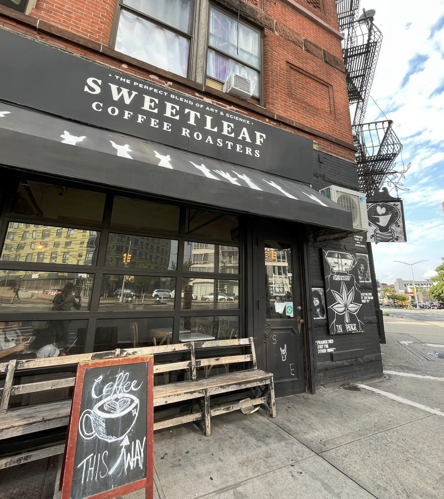 The black storefront with the Sweetleaf Coffee Roasters awning and a chalkboard sandwich sign outside